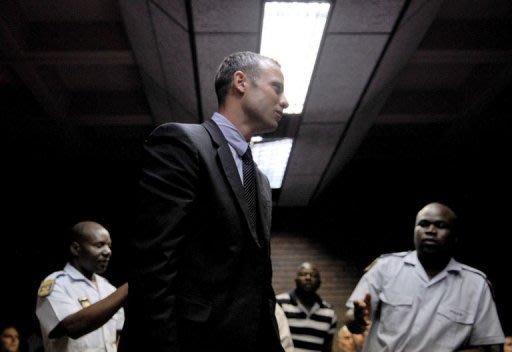 Oscar Pistorius leaves a Pretoria courtroom on February 15, 2013 after his hearing on charges of murdering his girlfriend Reeva Steenkamp. She is to be cremated Tuesday as the South African "Bladerunner" athlete appears in court for a bail hearing expected to reveal more about what happened the night she was shot dead