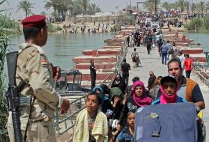 Iraqi security forces stand guard as residents from &hellip;