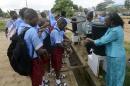A teacher demonstrates washing procedures to pupils prevent the spread of the Ebola virus at a school in Lagos on October 8, 2014