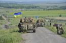 Members of the Ukrainian armed forces gather on the roadside near the village of Vidrodzhennya