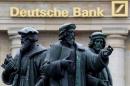 FILE PHOTO - A statue is pictured next to the logo of Germany's Deutsche Bank in Frankfurt