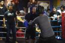 Pakistani gym owner Bashir Ahmad (L) watches as young boxers take part in a training session at a gym in Lahore on November 16, 2014