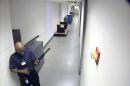 This image from video provided by the FBI, shows Aaron Alexis moving through a hallway of Building #197 at the Washington Navy Yard in Washington, carrying a Remington 870 shotgun. Senior U.S. officials say the company that employed the Washington Navy Yard shooter withdrew his access to classified material for two days in August when mental health problems became evident, but restored it quickly and never told the Navy about the incident. (AP Photo/FBI)