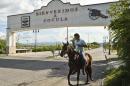 A horseman goes through the arch welcoming to the village of Cocula, Guerrero State, Mexico, on October 20, 2014