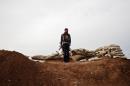 A member of the Kurdish Committees for the Protection of the Kurdish People (YPG) stands in the Syrian Kurdish town of Ras al-Ain on November 21, 2013