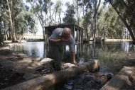 El río Jordán no es profundo ni ancho estos días. El caudal bíblico, que ha inspirado incontables canciones de folk espirituales, es un estrecho arroyo en gran parte de su cauce, contaminado y estancado. Pero eso va a cambiar. En la imagen, Ramon Ben Ari, director de la Autoridad de Drenaje del Jordán Sur, bebe agua de una fuente rehabilitada cerca del río Jordán, el 16 de julio de 2012. REUTERS/Baz Ratner