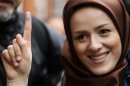 Voter Zeynab shows the ink stain on her finger, to prove that she has voted, outside the Iranian consulate in central London