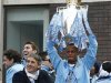 Manchester City captain Kompany lifts the English Premier League trophy as he stands with manager Mancini during a victory bus parade through the city of Manchester