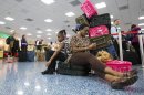 Daija Walker, left, and Andrea Clarke sit next to their luggage at the Miami International Airport, Tuesday, April 16, 2013, in Miami, as they tried to get back home to Barbados. A computer system used to run many daily operations at American Airlines failed Tuesday, forcing the nation's third-largest carrier to ground all flights across the United States for several hours and stranding thousands of frustrated passengers at airports and on planes. (AP Photo/J Pat Carter)