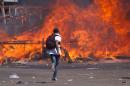 Zimbabwe's opposition supporters set up a burning barricade as they clash with police during a protest for electoral reforms in Harare on August 26, 2016