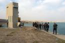 Iraqi troops and members of their Kurdish and Shiite militia allies stand next to Al-Udhaim dam after reportedly recapturing the dam from Islamic State (IS) militants in the ethnically mixed Diyala province, on November 14, 2014