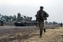 A Congolese soldier runs past a tank in Kanyarucinya, around 10 km from Goma in DR Congo on July 17, 2013