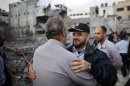 Hamas police officer is hugged by a Palestinian man after they returned to their destroyed police headquarters in Gaza