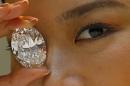FILE - In this Thursday, Sept. 19, 2013 file photo, a 118.28-carat white diamond is displayed by a model at a press preview at Sotheby's auction house in Hong Kong. The white diamond the size of a small egg has sold for $27.3 million dollars at a Hong Kong auction. A phone bidder bought the rock from Africa at the Monday night, Oct. 7 sale. The price edged out the previous price record for a white diamond of $26.7 million set at Christie's in Geneva in May. (AP Photo/Vincent Yu, File)