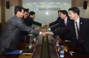 In this photo released by Unification Ministry, South Korean delegates, right, shake hands with their North Korean counterparts at the start of a meeting at Kaesong Industrial District Management Committee in Kaesong, North Korea, Wednesday, Sept. 11, 2013. Both Koreas agreed Wednesday to restart operations at a jointly run factory park that Pyongyang shut down in April during a torrent of threats, the latest sign of easing animosity between the rivals. (AP Photo/Unification Ministry)