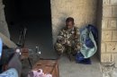 A man suspected of being a Jihadist, arrested by Malian forces in Lere, sits at the police station where he is being held in Timbuktu, Mali, Friday Feb. 1, 2013. French President Francois Hollande is scheduled to visit the fabled city Saturday. (AP Photo/Harouna Traore)