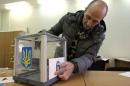 An election commission worker adjusts a number on a ballot box at a polling station in Kiev