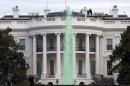 Members of the Secret Service patrol the top of the White House in Washington, Tuesday, March 17, 2015, as while a fountain has been dyed green for St. Patrick's Day. (AP Photo/Jacquelyn Martin)