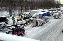 In this photo provided by the Indiana State Police, emergency crews work at the scene of a massive pileup involving about 15 semitrailers and about 15 passenger vehicles and pickup trucks along Interstate 94 Thursday afternoon, Jan. 23, 2014 near Michigan City, Ind. At least three were killed and more than 20 people were injured. (AP Photo/Indiana State Police)