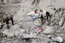 Syrians look through rubble following a reported airstrike attack by governmeet forces on Daraya, southwest of the capital Damascus, on January 25, 2014