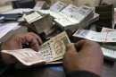 An employee counts Indian rupee notes at a cash counter inside a bank in Agartala