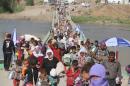 Displaced Iraqis from the Yazidi community cross the Syrian-Iraqi border along the Fishkhabur bridge over the Tigris River, in northern Iraq, on August 13, 2014