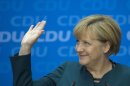 German Chancellor Angela Merkel waves as she gives a press conference in Berlin, on September 23, 2013