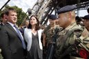 French Interior Minister Manuel Valls, left, and Junior Minister of Crafts, Business and Tourism Sylvia Pinel , second left, talk with French soldiers during a visit with journalists next to the Eiffel Tower in Paris Friday Aug. 2, 2013 during a tour focused on security at the city's top tourist areas. (AP Photo/Francois Mori)