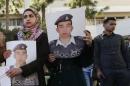 Students hold pictures of Islamic State captive Kasaesbeh during a rally calling for his release, in Amman