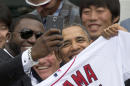 FILE - In this Tuesday, April 1, 2014, file photo, Boston Red Sox designated hitter David "Big Papi" Ortiz takes a selfie with President Barack Obama, holding a Boston Red Sox jersey presented to him, during a ceremony on the South Lawn of the White House in Washington, where the president honored the 2013 World Series baseball champion Boston Red Sox. Ortiz tweeted the selfie to his followers Tuesday, and it was resent by tens of thousands, including Samsung, which retweeted it as an ad. The White House press secretary says Obama was not aware that the photo was part of a marketing stunt. (AP Photo/Carolyn Kaster, File)