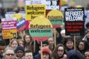 Demonstrators hold placards during a refugees welcome march in London