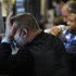 A trader places his hand on his face next to other traders working on the floor of the New York Stock Exchange