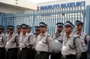 Indian private security guards stand guard at the main gate of Maruti Suzuki Production Facllity in Manesar