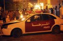 A damaged police car is seen outside a security forces building that was attacked by a crowd of protesters in Benghazi