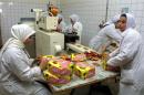 Iraqi women work at a sweets factory in Baghdad on February 12, 2002, producing one ton of sweets daily, using local ingredients except for the imported chocolate