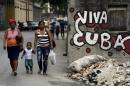 People walk near graffiti that reads "Long live Cuba" in Havana