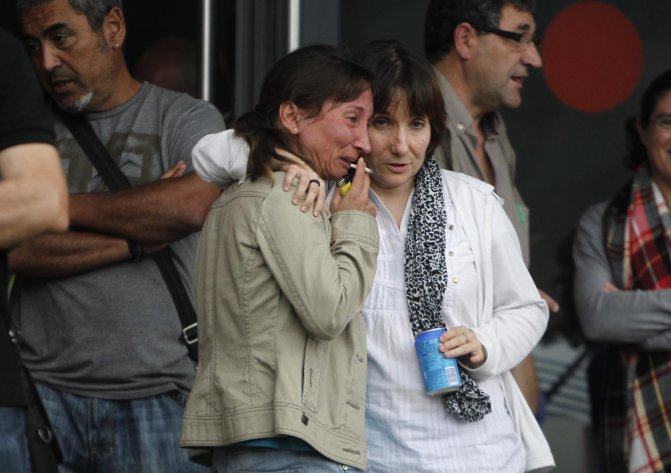 Relatives of victims involved in a train accident wait for news at a victims information point in Santiago de Compostela, Spain, on Thursday July 25, 2013. The death toll in a passenger train crash in northwestern Spain rose to 77 on Thursday after the train jumped the tracks on a curvy stretch just before arriving in the northwestern shrine city of Santiago de Compostela, a judicial official said. (AP Photo/Salome Montes)