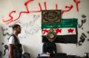A rebel of the "Shuhada al-Atareb" brigade of the Free Syrian Army stands inside the group's headquarters in the Sukkari district of the northern city of Aleppo on August 14, 2012