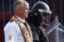 A member of the Orange Order is flanked by a riot police officer during a march in Belfast