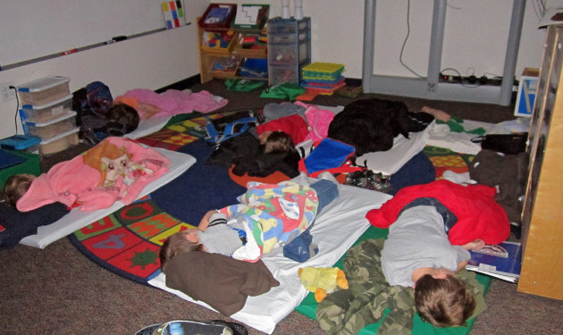 In this photo provided by Sharon Webb, principal of Miami-Yoder School, students sleep on the floor at the school on Wednesday, Feb. 25, 2013, in Yoder, Colo. About 60 students were forced to spend the night at the school after snow drifts closed roads in the area. The students went home later Wednesday after the roads were cleared. (AP Photo/Sharon Webb)
