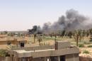 Smoke billows from Husaybah, an Iraqi rural town in the Euphrates Valley east of Ramadi, on July 16, 2015