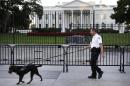 FILE - In this Sept. 22, 2014, file photo, a member of the Secret Service Uniformed Division with a K-9 walks along the perimeter fence along Pennsylvania Avenue outside the White House in Washington. An Army veteran who got over the White House fence and inside the executive mansion before being stopped is about to be sentenced. Omar Gonzalez is scheduled to appear in federal court in Washington for a sentencing hearing Tuesday. Gonzalez's lawyer is asking a judge to sentence him to time served and says he deserves leniency because of his Army service. Prosecutors are asking that Gonzalez spend nearly two years in prison. (AP Photo/Carolyn Kaster, File)