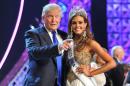 FILE - In this June 16, 2013, file photo, Donald Trump, left, and Miss Connecticut USA Erin Brady pose onstage after Brady won the 2013 Miss USA pageant in Las Vegas. The Reelz channel said Thursday, July 2, 2015, it will carry Trump's Miss USA pageant that was dropped by NBC after Trump made critical comments about immigrants from Mexico. (AP Photo/Jeff Bottari, File)