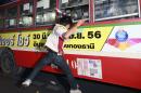 An anti-government protester attacks people they suspected of supporting the current Thai government on the bus in Bangkok,Thailand Saturday, Nov. 30, 2013. A mob of anti-government protesters smashed the windows of a moving Bangkok bus Saturday in the first eruption of violence after a week of tense street protests.(AP Photo/Wason Wanichakorn)