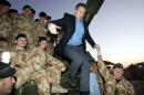 A long-awaited public inquiry into Britain's role in the Iraq war will highlight the actions of Prime Minister Tony Blair (C), pictured in Basra, Iraq on December 21, 2004, and his administration