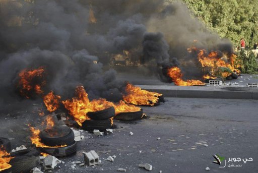 Demonstrators burn tyres during a protest against Syria's President Assad in Jubar