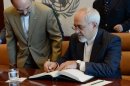 Iran's Foreign Minister Javad Zarif (R) signs a guest book on September 19, 2013 at UN headquarters in New York