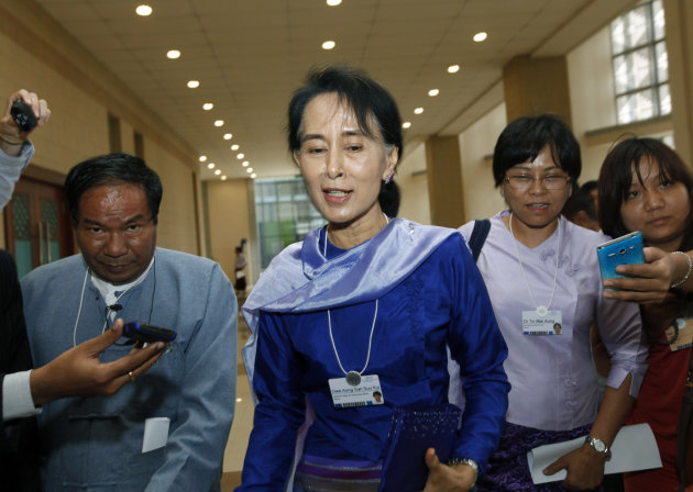 Myanmar opposition leader Aung San Suu Kyi speaks to journalists as she leaves Myanmar International Convention Center after attending the first day of the three-day World Economic Forum for East Asia in Naypyitaw, Myanmar, Wednesday, June 5, 2013. (AP Photo/Khin Maung Win)