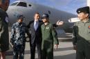 Australian Prime Minister Tony Abbott, center, gathers for a picture in front of a Royal Australian Air Force AP-3C Orion aircraft with the leaders of Chinese, Japanese and South Korean military efforts searching for the missing Malaysia Airlines Flight MH370 at RAAF Base Pearce near Perth Monday, March 31, 2014. Pictured with Abbott are from second left to right, China's Air Force Senior Colonel Liu Dian Jun, Abbott, Japan's Maritime Self Defense Force Commander Hidetsugu Iwamasa and South Korean Navy Captain Lee Jin-young. (AP Photo/Jason Reed, Pool)