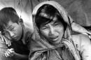 In this November 30, 1977, file photo, Vietnamese refugee Nguyen Thi Yen, holds her sick child as she asks for help while sitting in a fishing boat carrying her and 48 other refugees as they arrive at Khlong Yai, a village 220 miles southeast of Bangkok, Thailand. The refugees were refused entry by Thai authorities and the boat was towed back to sea. Two recent shipwrecks in the Mediterranean Sea believed to have taken the lives of as many as 1,300 asylum seekers and migrants has highlighted the escalating flow of people fleeing persecution, war and economic difficulties in their homelands. (AP Photo/Eddie Adams, File)